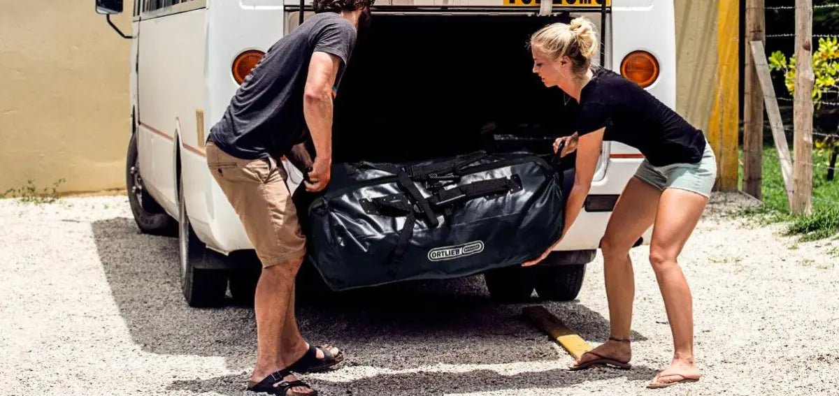 Durable waterproof holdall bag being loaded into a camper van.