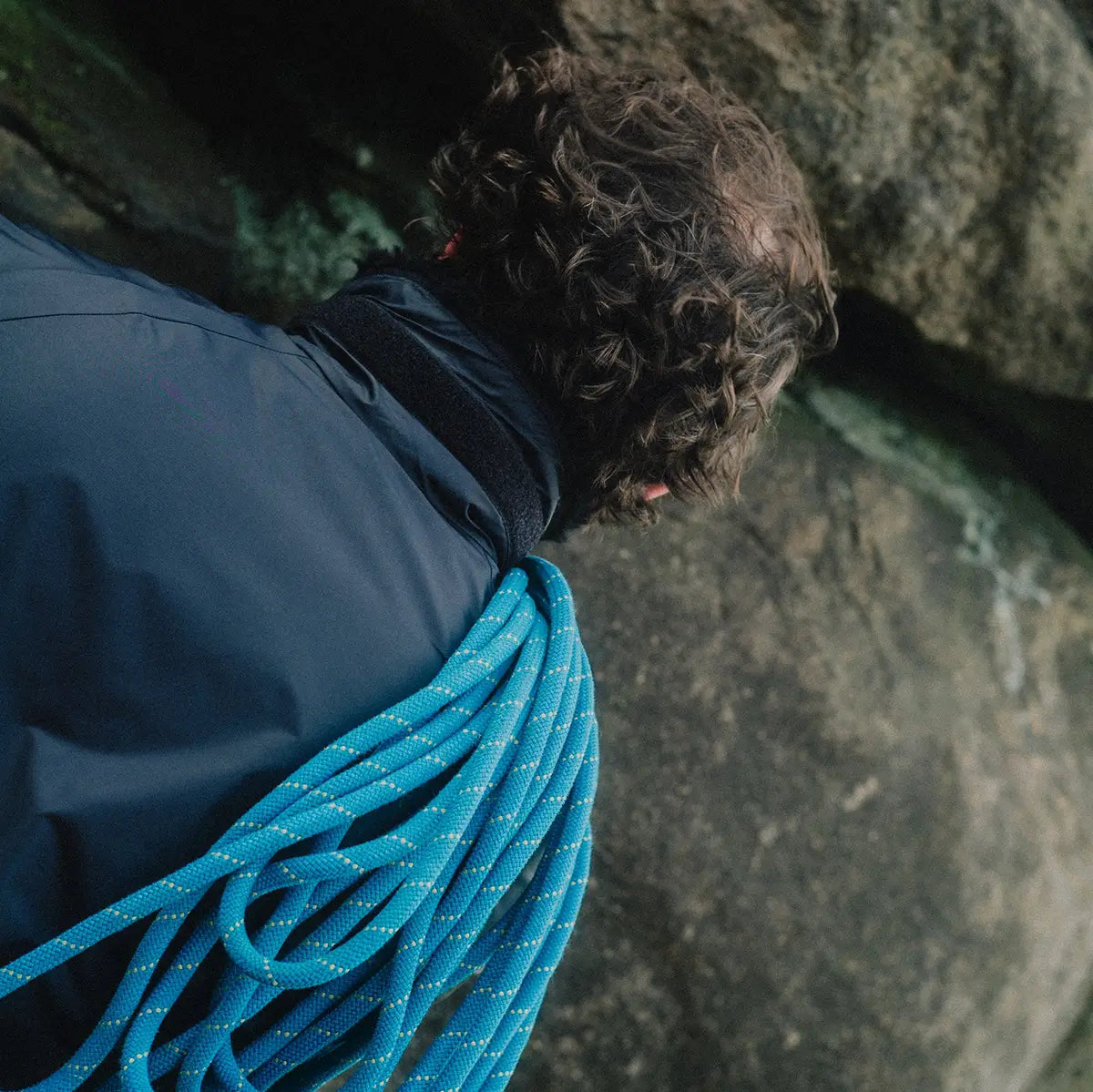 Back view of climber wearing Buffalo Mens Pertex Belay Jacket with rope over shoulder, built for cold and challenging environments.
