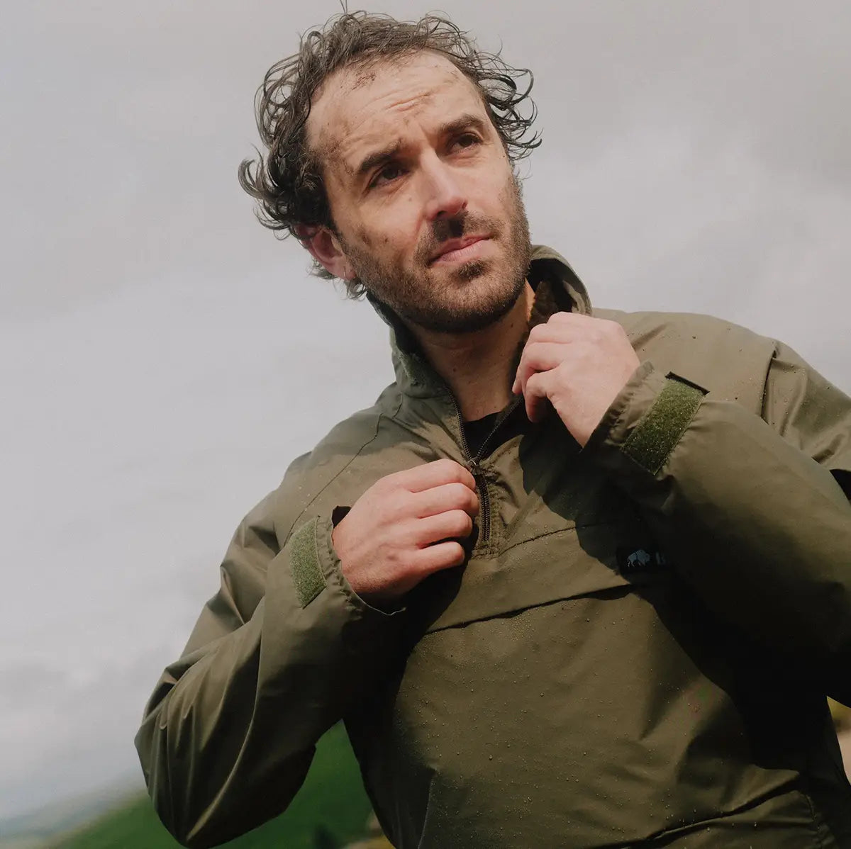 Man wearing olive green Buffalo Systems Special 6 Shirt adjusting collar, demonstrating fit and function in outdoor cold weather setting.