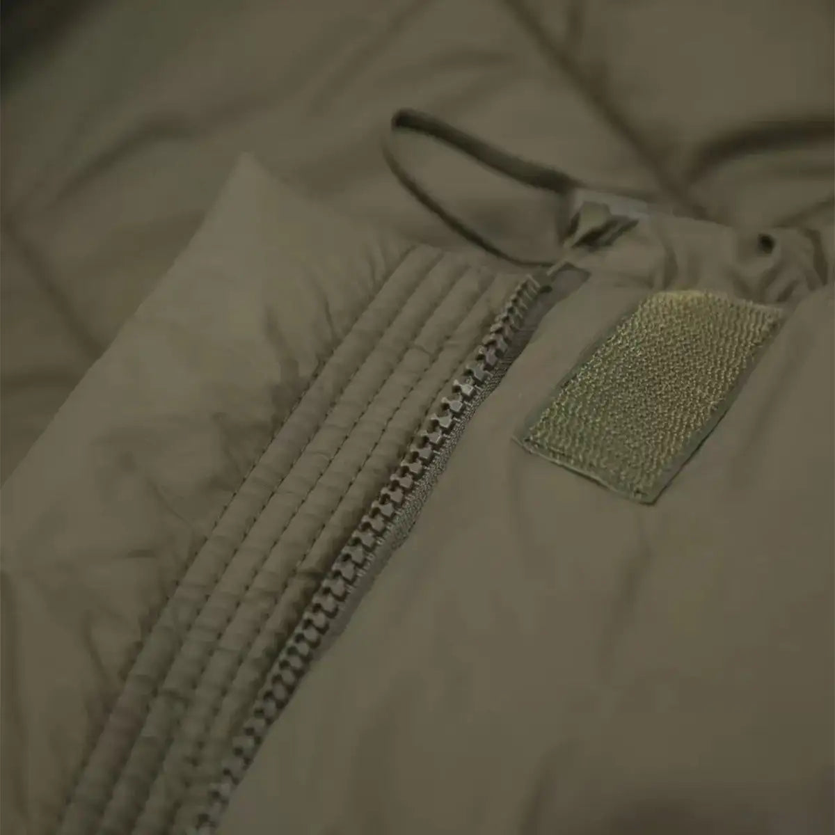 Close-up of the Carinthia Defence 4 Sleeping Bag Olive Green zipper system with reinforced stitching for durability and secure closure. from John Bull Clothing