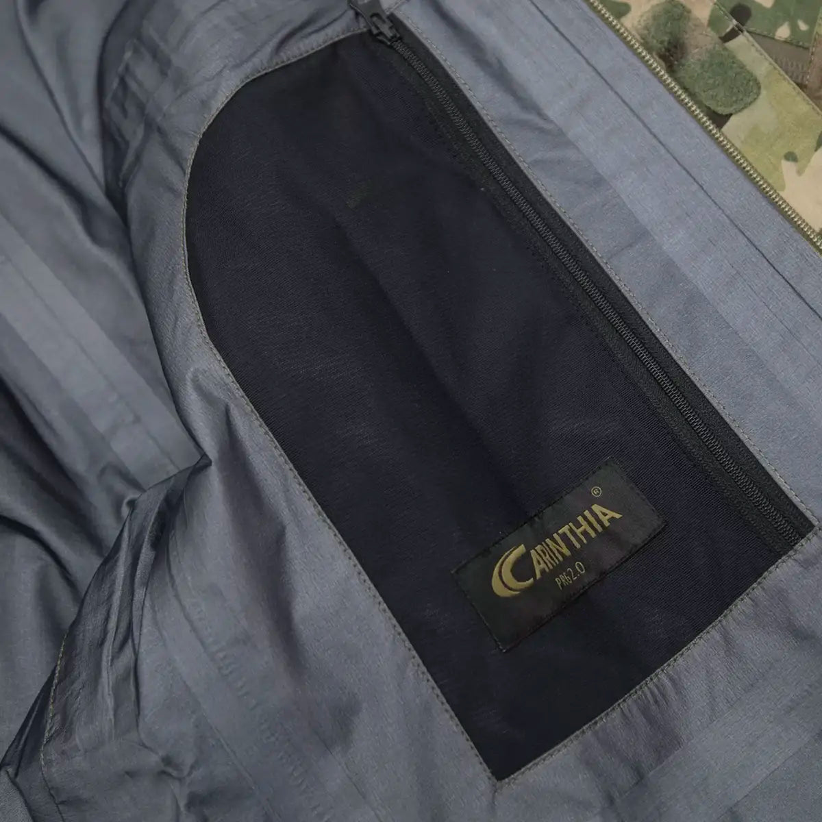 Interior pocket detail of Carinthia PRG 2.0 Waterproof Jacket Multicam with branded label and zippered storage compartment.