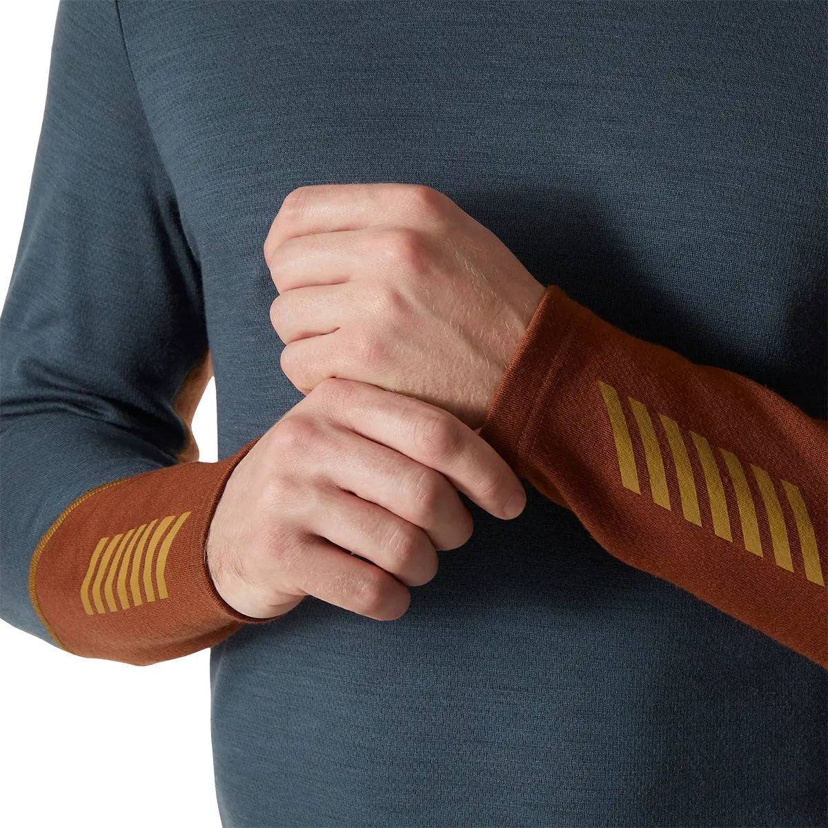 Close-up of Helly Hansen Lifa Merino Midweight Crew Base Layer sleeve with brown and gold design, highlighting the soft and flexible Merino fabric.