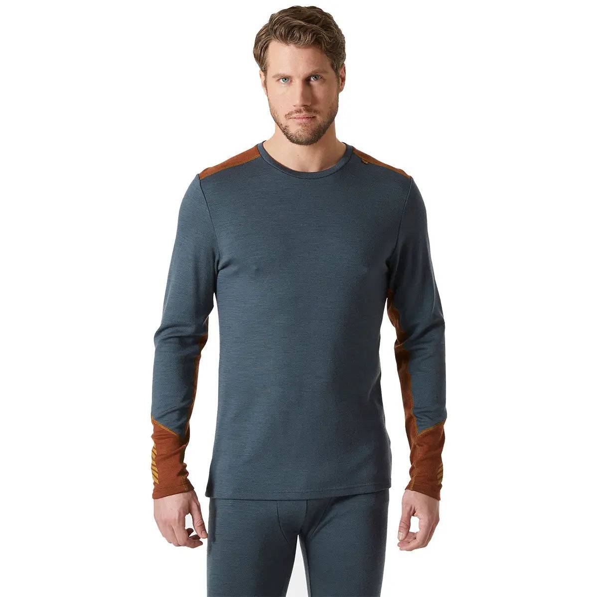 Model wearing Helly Hansen Lifa Merino Midweight Crew Base Layer in dark teal, showing its snug fit and stylish design for outdoor performance.