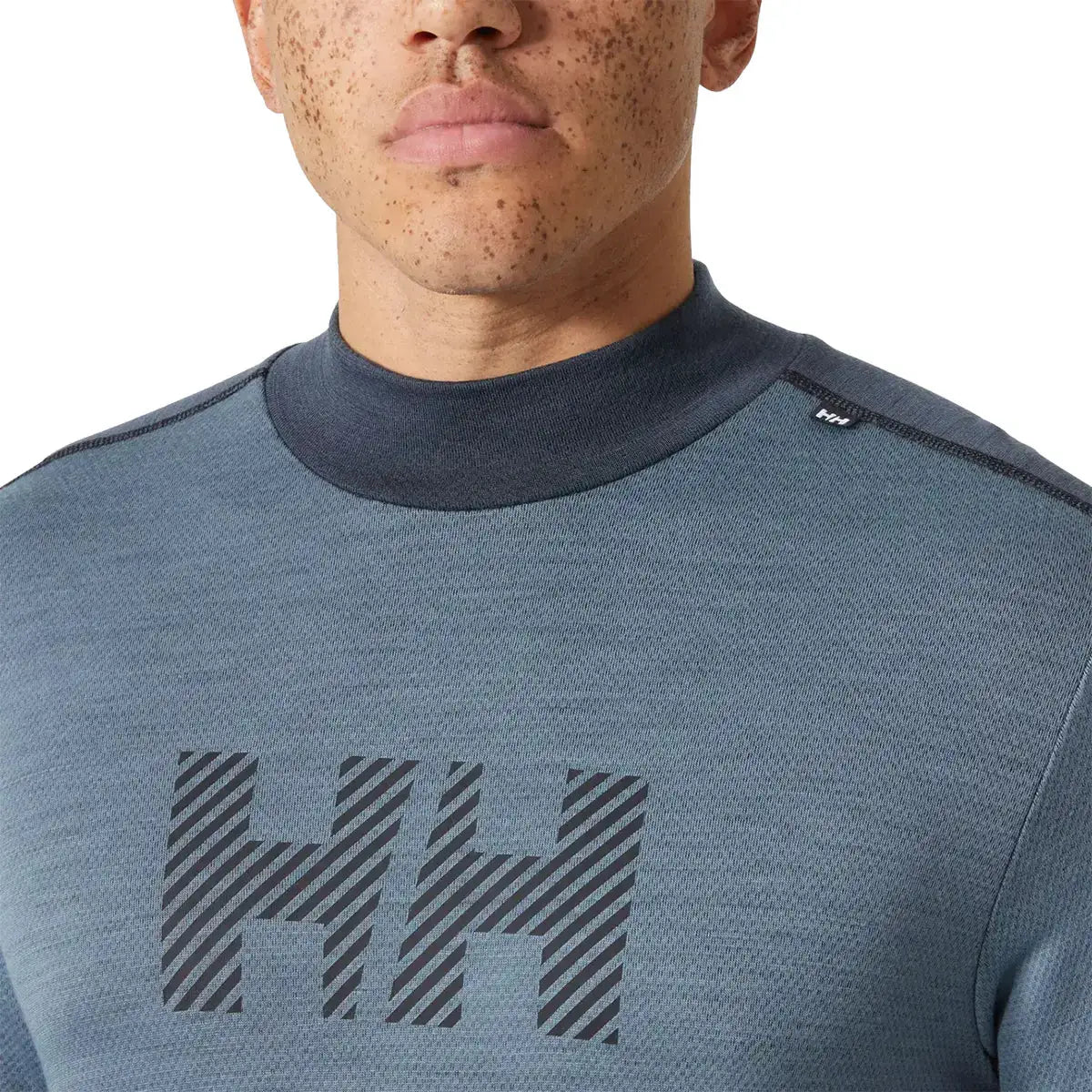 Zoomed-in view of Helly Hansen Lifa Midweight Logo Merino Base Layer chest logo and collar, emphasizing branding and soft merino blend fabric. from John Bull Clothing