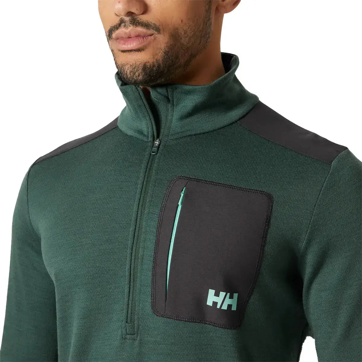 Close-up of Helly Hansen Lifa Merino Wool Mid Layer 1/2 Zip chest pocket with HH logo and contrast zipper, highlighting functional outdoor design. from John Bull Clothing