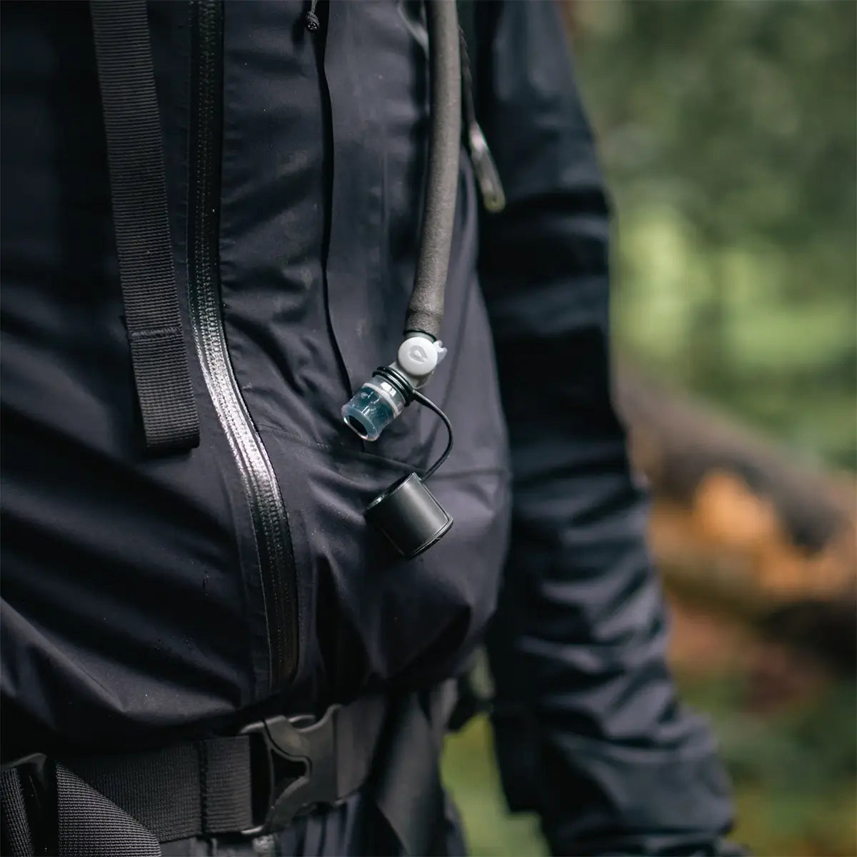 HydraPak Force Tactical Grey Water Reservoir hose clipped to tactical jacket, perfect for hands-free hydration | John Bulls