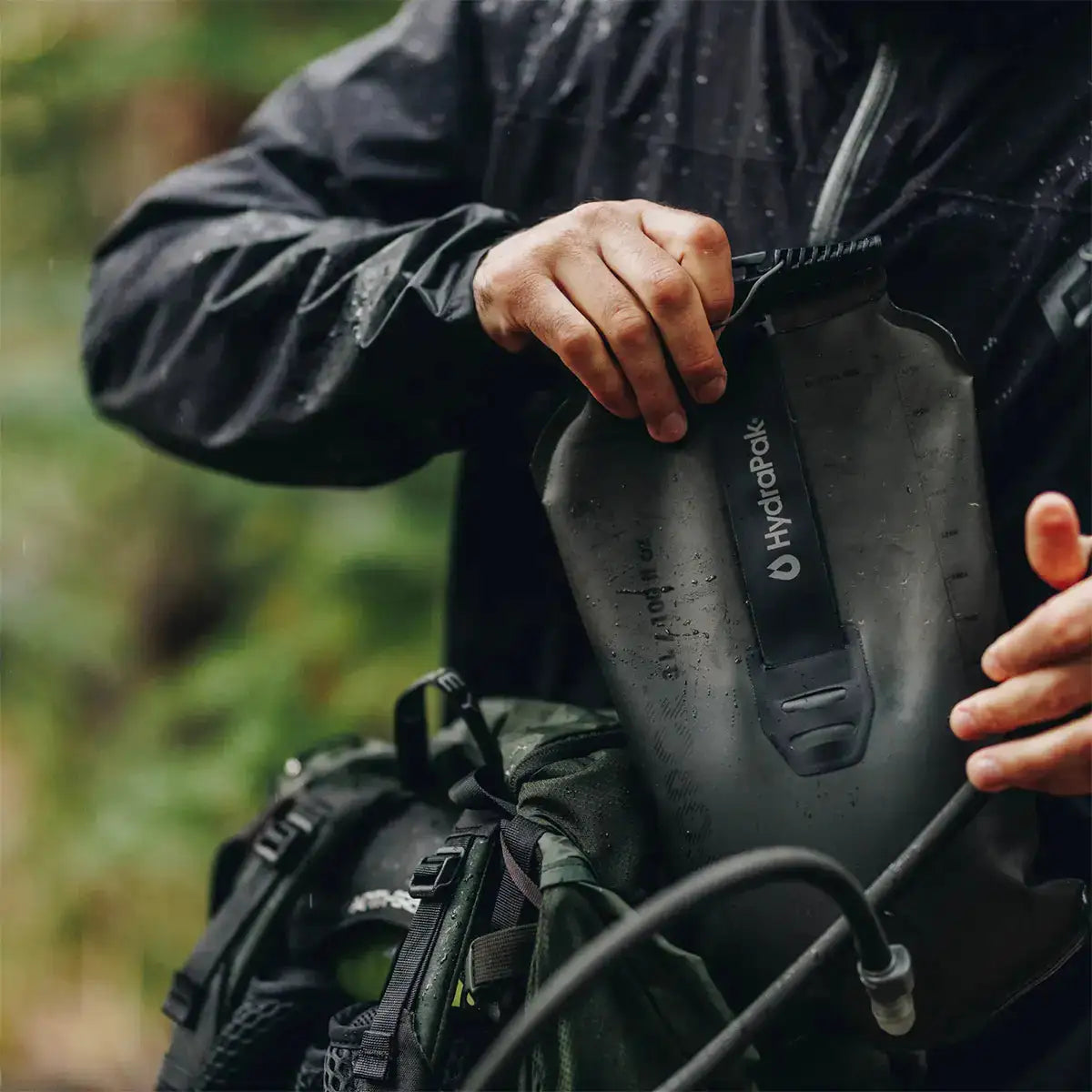 HydraPak Force Tactical Grey Water Reservoir being filled in a forest setting, ideal for tactical and mountaineering use | John Bulls from John Bull Clothing