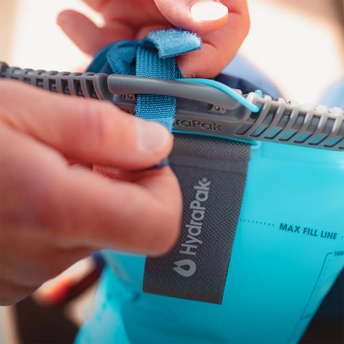 Close-up of the HydraPak Velocity Hydration Water Reservoir top seal being secured, emphasizing its leak-proof and user-friendly design.