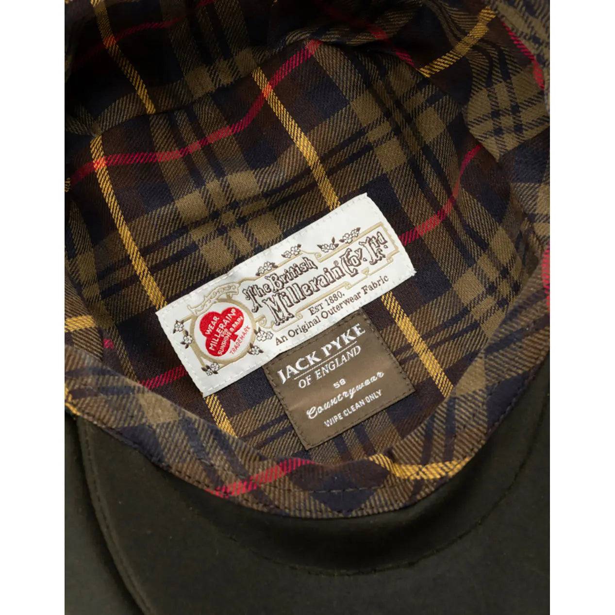 Interior of the Jack Pyke Wax Flat Cap Green, revealing a stylish tartan lining and branded labels for authenticity.