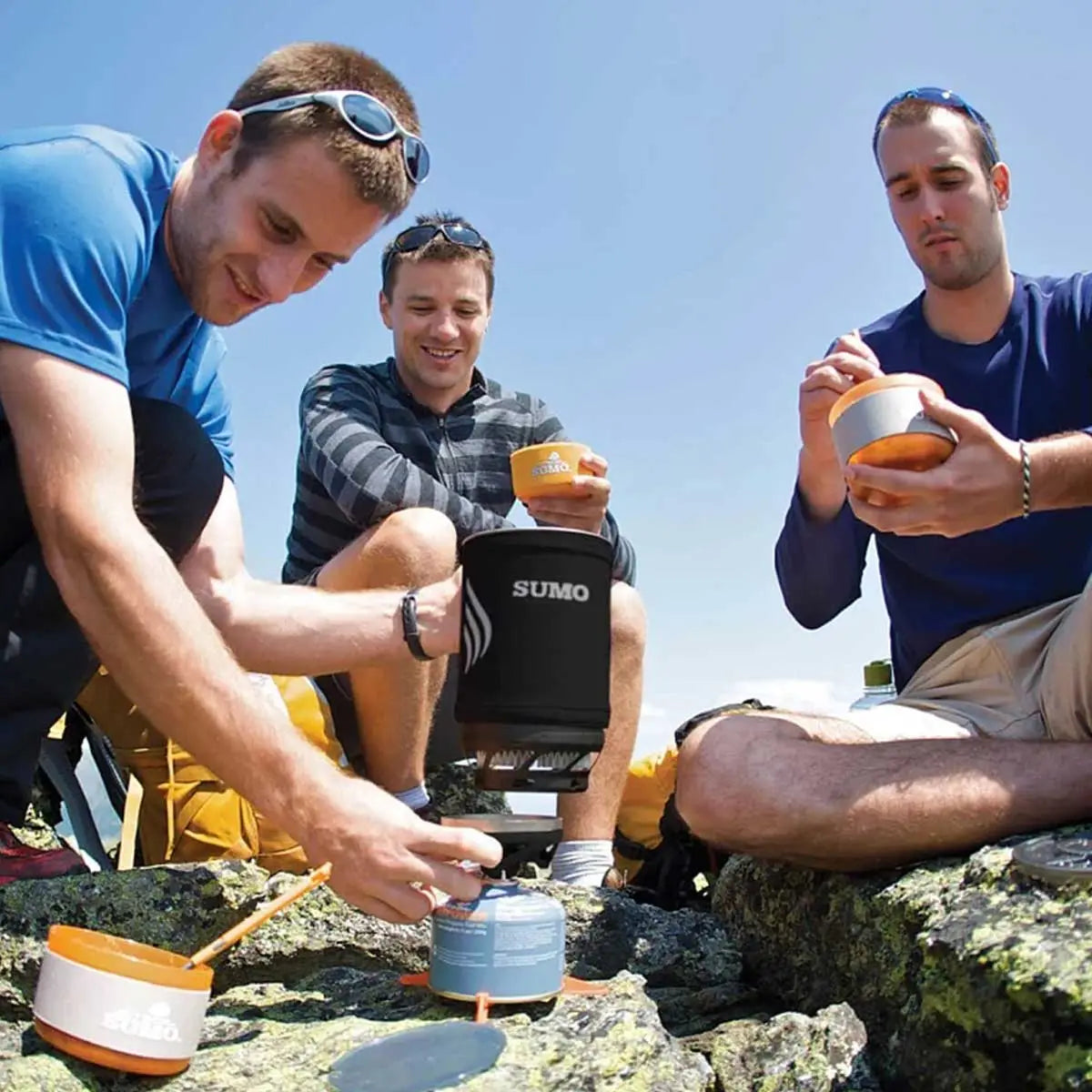 Group of hikers using Jetboil Sumo Carbon 1.8L Cooking System to prepare a meal outdoors. Ideal for group camping and backpacking trips.