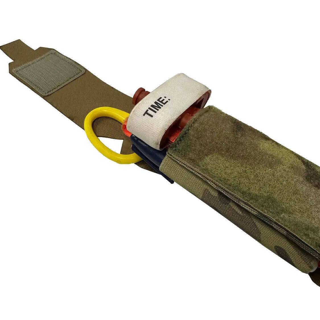 Close-up of Luminae Multicam TQ Pouch MTP with a tourniquet and medical shears partially exposed. Ensures rapid deployment for critical care.