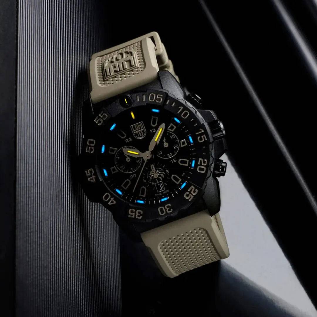 Luminox Navy SEAL Foundation Chronograph Dive Watch glowing in low light, showcasing its blue and yellow luminescent markers.