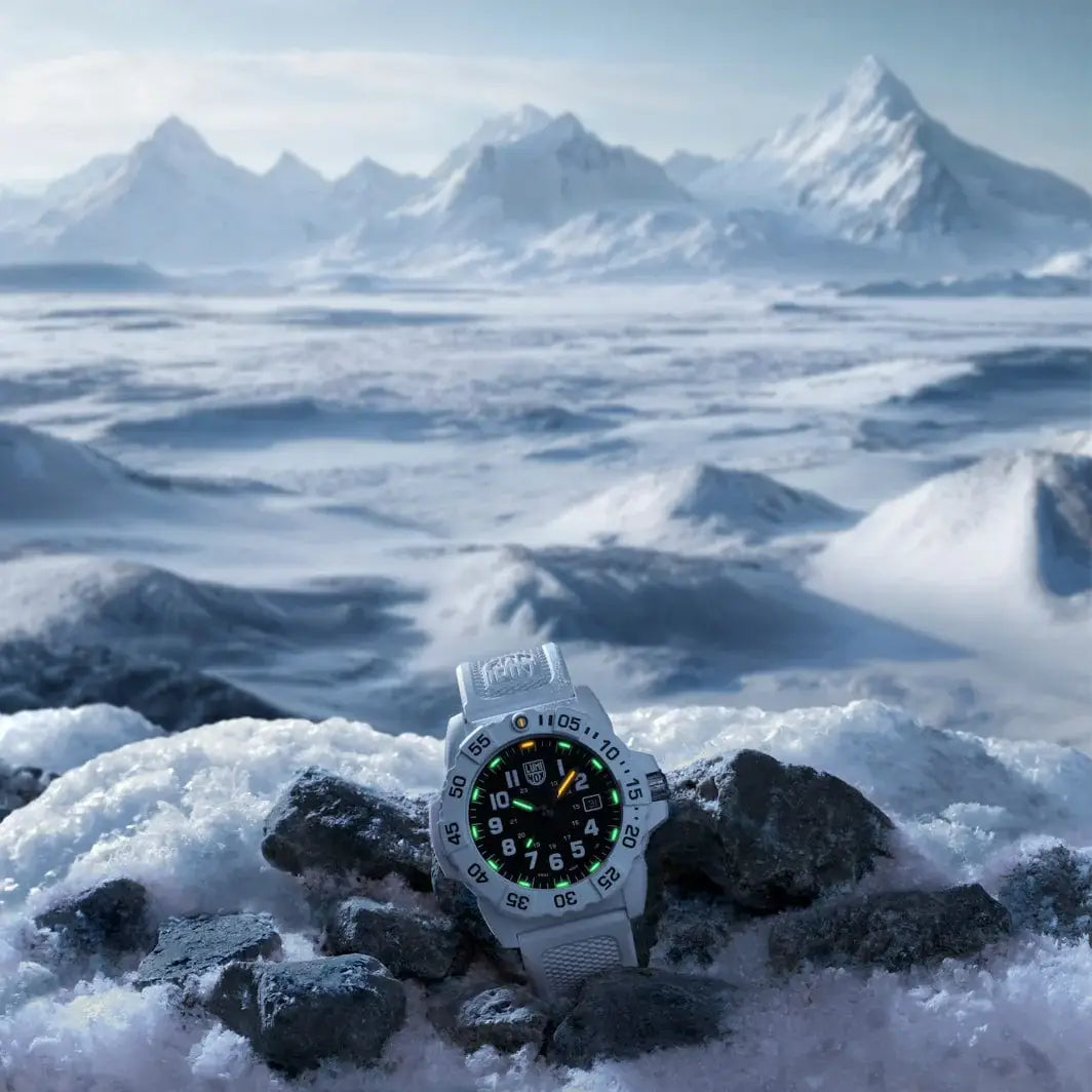 Luminox Navy Seal White Military Dive Watch 45mm XS.3507.WB glowing in snowy mountain landscape, symbolizing survival gear in harsh environments.