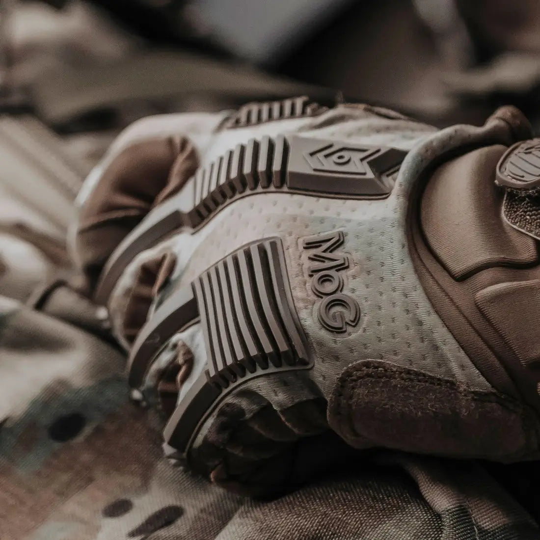 Detailed view of MoG Target High Abrasion Ergoshield Gloves in Multicam showing textured backhand protection and branding for industrial and tactical use.