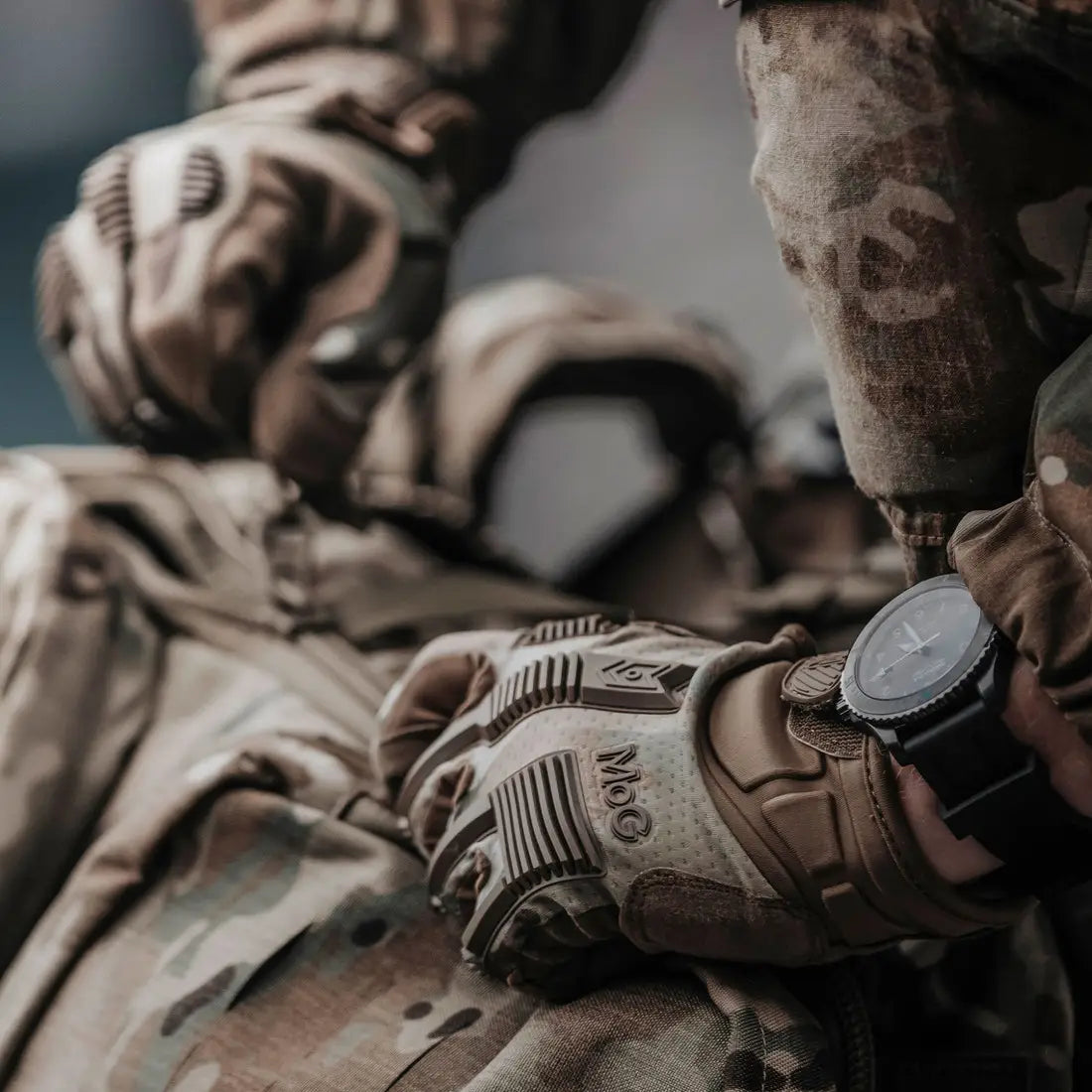 Close-up of MoG Target High Abrasion Ergoshield Gloves in Multicam during field operation, emphasizing rugged design and protective features for professionals.