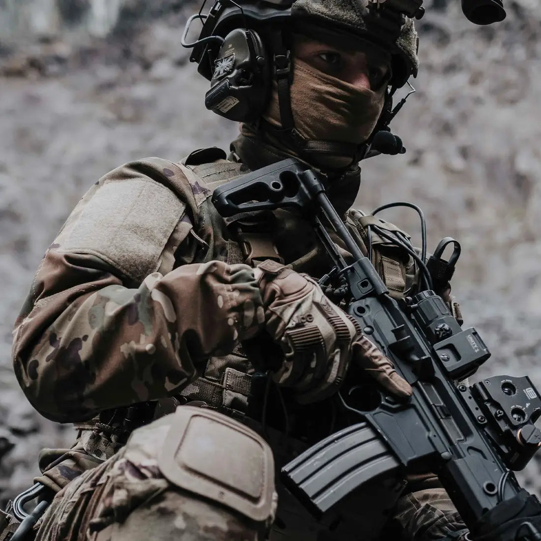 Operator wearing MoG Target High Abrasion Ergoshield Gloves in Multicam while holding a rifle, showcasing tactical performance in combat-ready environments.