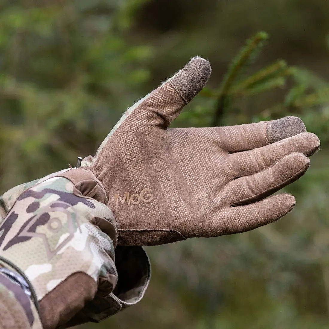 Close-up of MoG Target Light Duty Gloves Multicam palm grip in outdoor setting, emphasizing precision control and rugged construction for safety gear.