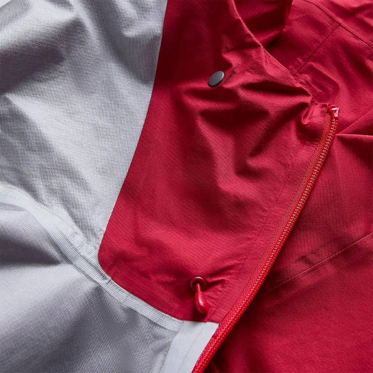 Detailed view of Montane Mens Cetus Lite Waterproof Jacket in red, showing the inner lining and waterproof zipper construction for enhanced protection.