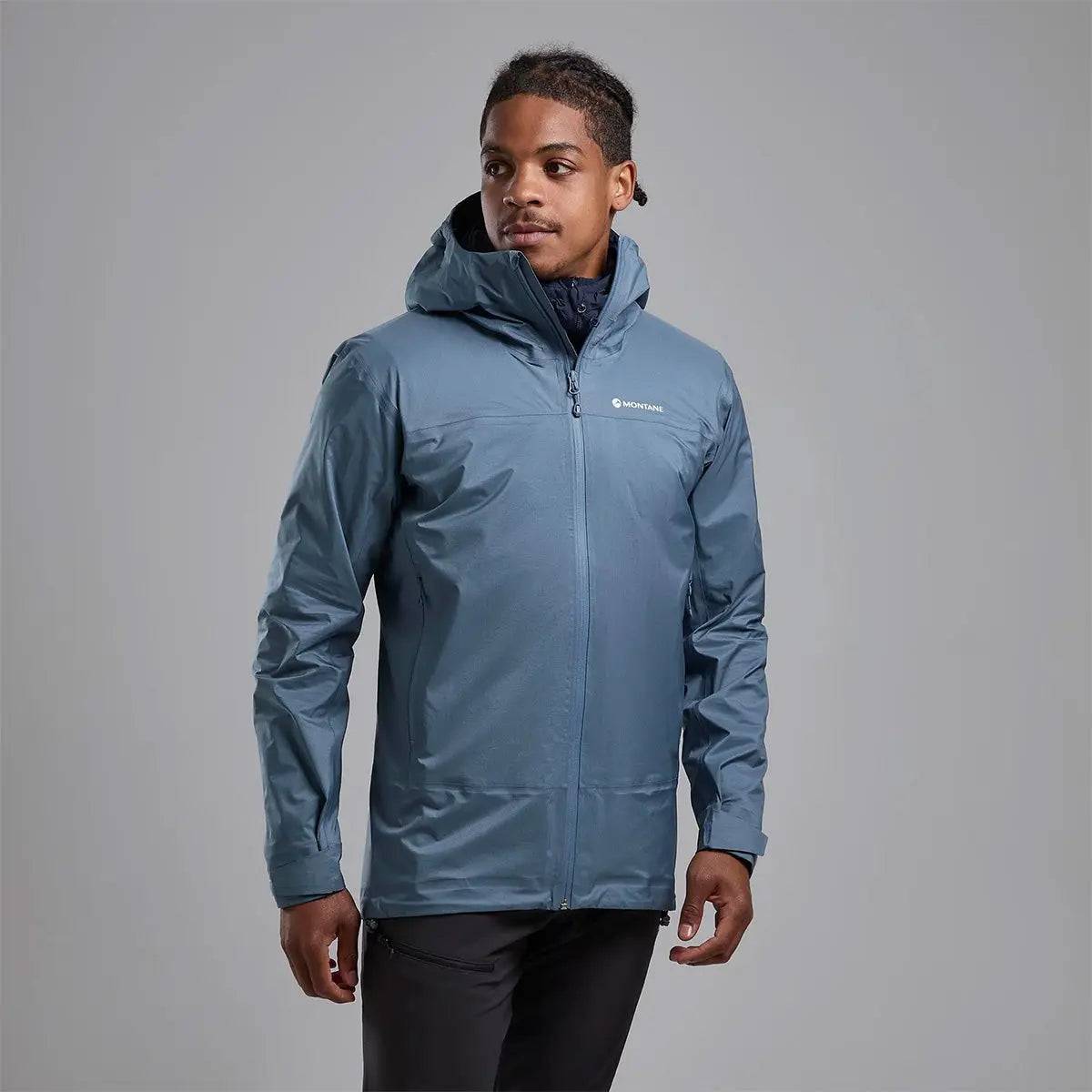 Model wearing Montane Mens Cetus Lite Waterproof Jacket in blue, showcasing its stylish and functional design for wet and windy conditions.