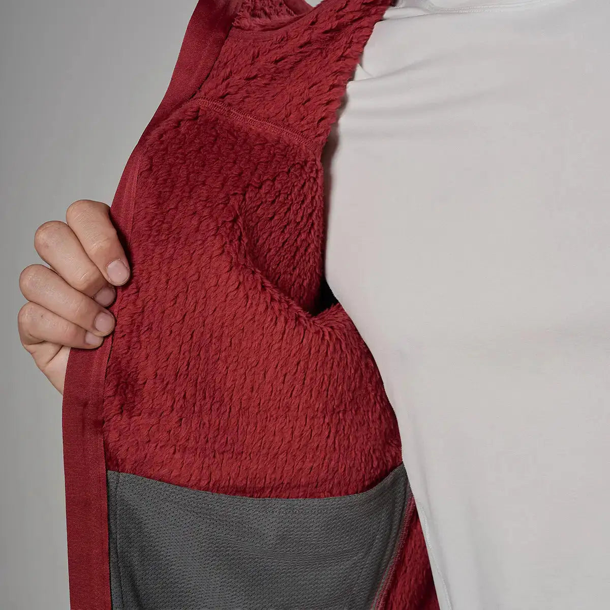 Close-up of a red fleece lining inside a men's outdoor jacket, showing textured, warm, and durable fabric for activewear