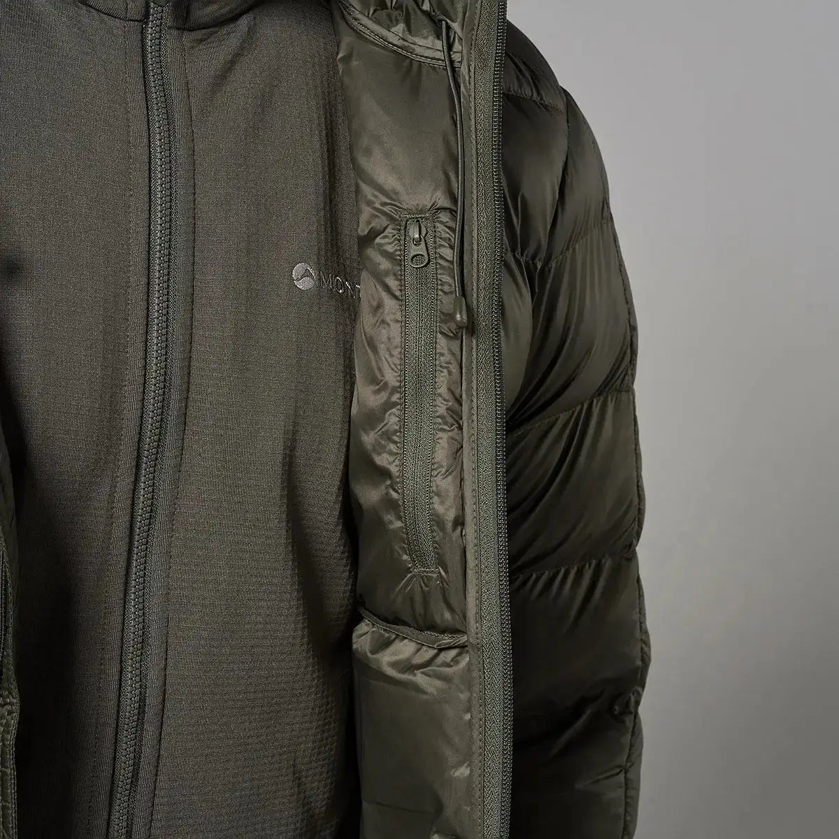 Close-up of Montane Mens Icarus 3.0 Hooded Insulated Jacket in dark green, showing textured fabric, zippers, and logo on chest