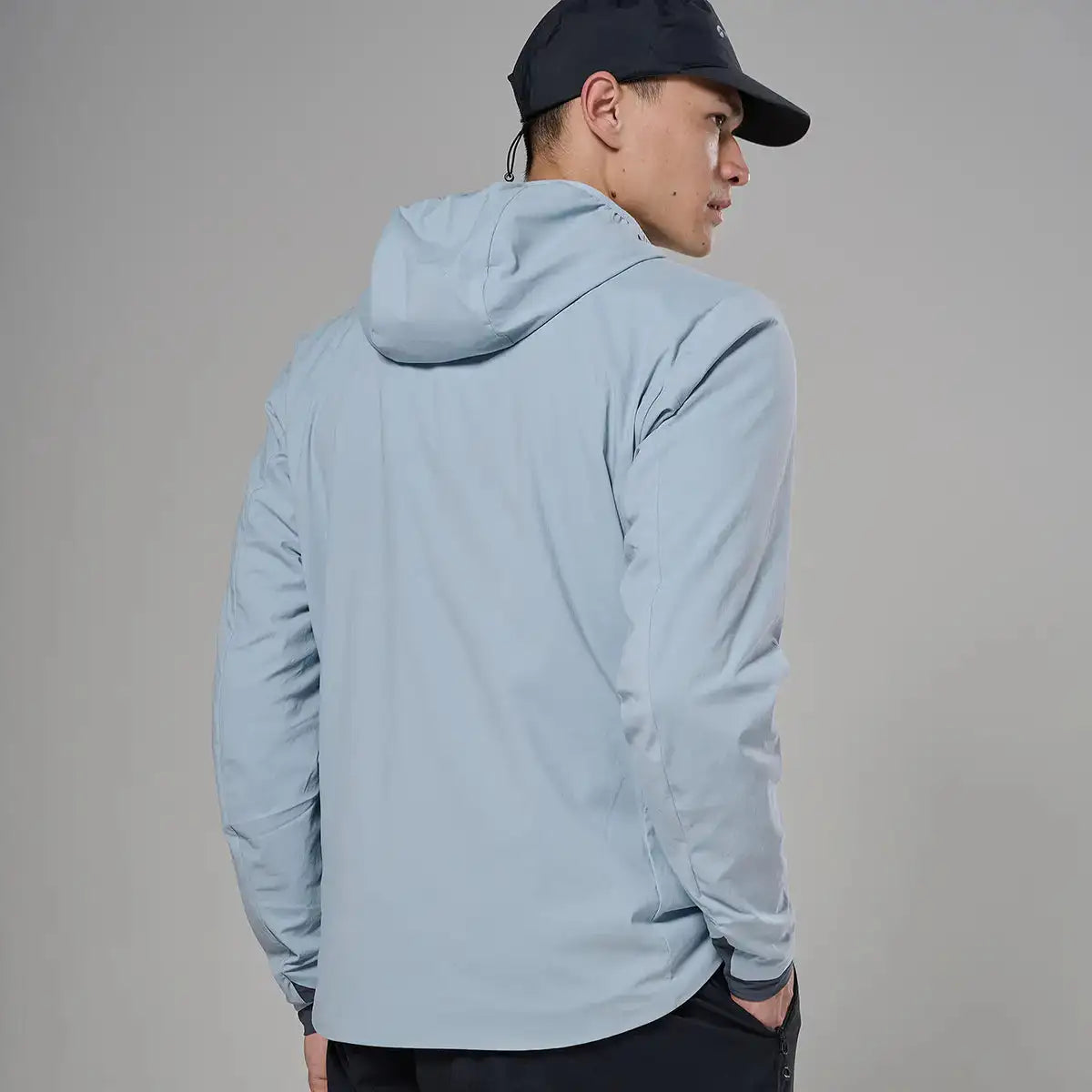 Male model wearing light gray softshell hooded jacket with black cap, side view, outdoor apparel for active wear, SKU: JB1617-MS-S