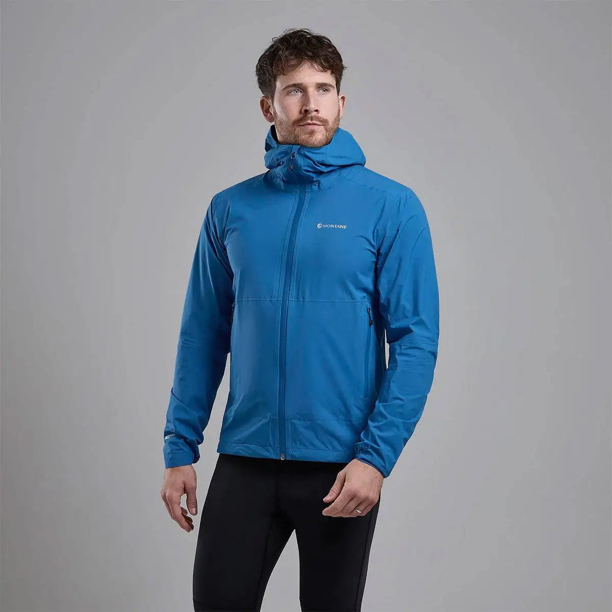 Montane Mens Minimus Lite Waterproof Jacket in blue worn by model, showcasing athletic fit and lightweight rain protection. from John Bull Clothing