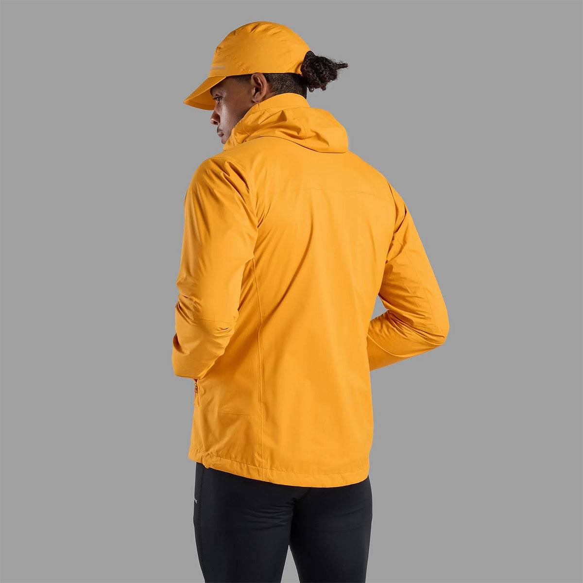 Back view of Montane Mens Minimus Lite Waterproof Jacket in orange, showcasing hood and ergonomic fit for active outdoor use.