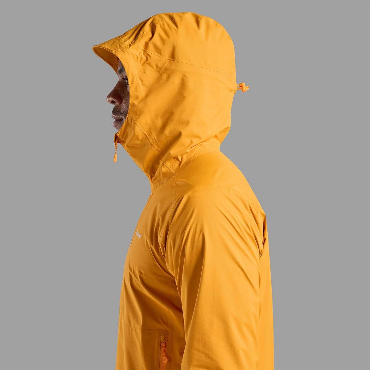 Hood detail on Montane Mens Minimus Lite Waterproof Jacket in orange, offering full head coverage for wet weather conditions.