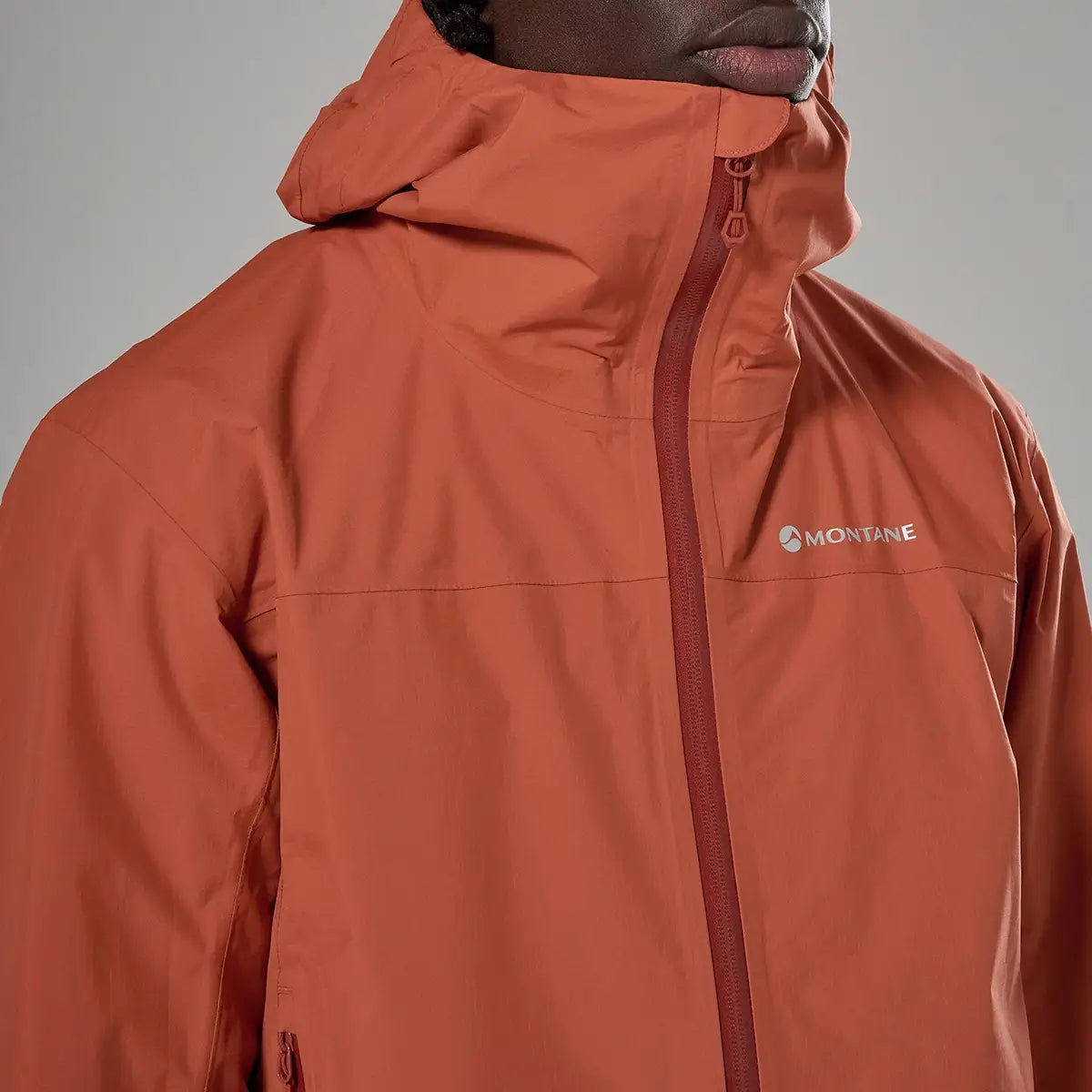 Close-up of orange Montane waterproof jacket with logo detail