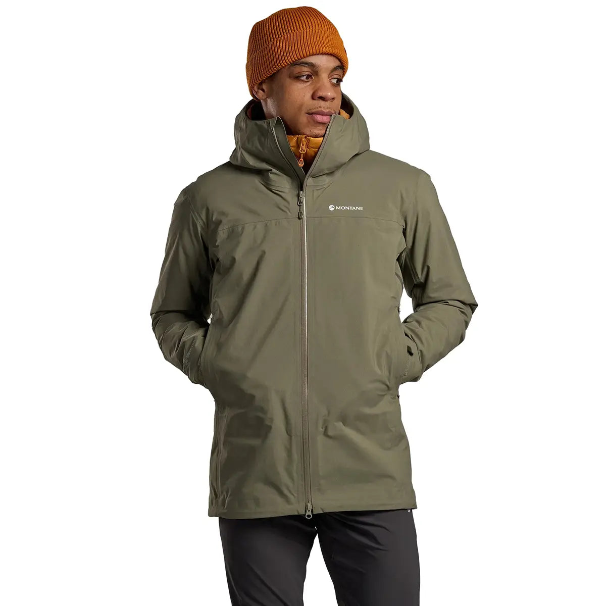 Model in green Montane Mens Phase Goretex Waterproof Jacket with hands in pockets, designed for comfort and rain protection.