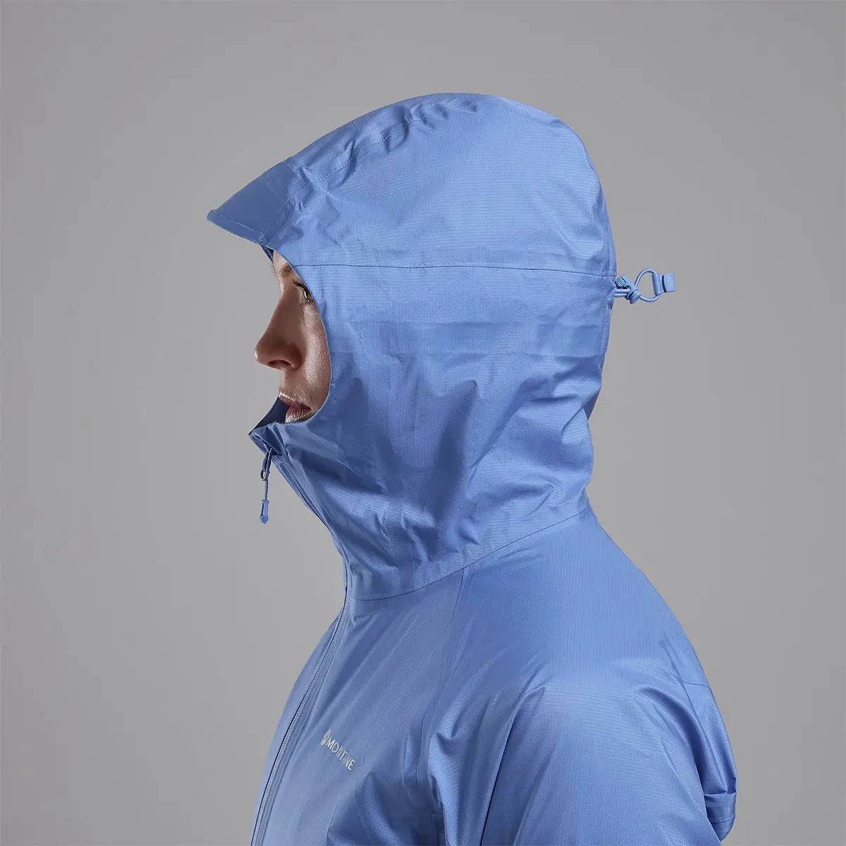 Side profile of Montane Women's Cetus Lite Waterproof Jacket in light blue, showing the adjustable hood and high collar for extra protection.