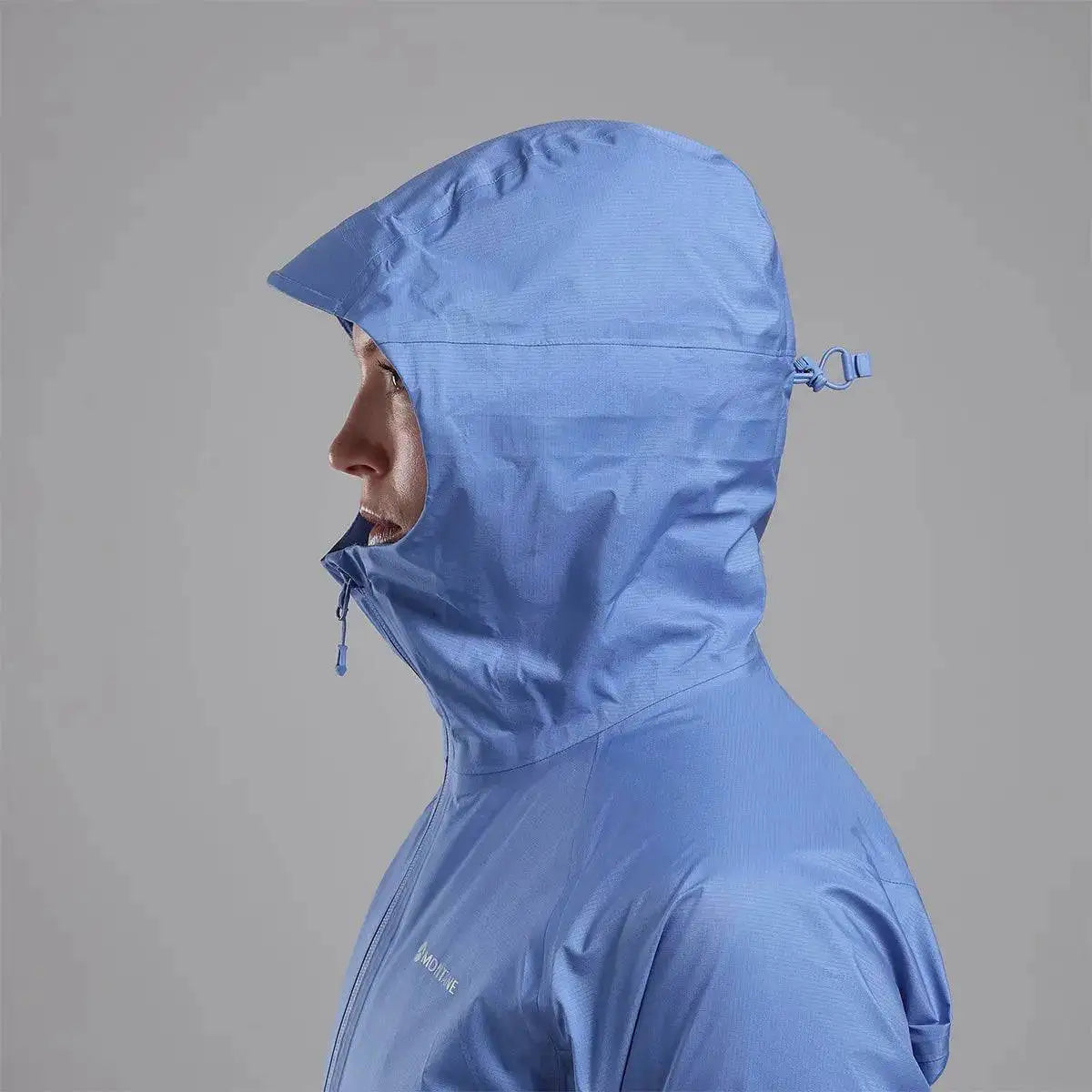 Side profile of Montane Women's Cetus Lite Waterproof Jacket in light blue, showing the adjustable hood and high collar for extra protection. from John Bull Clothing