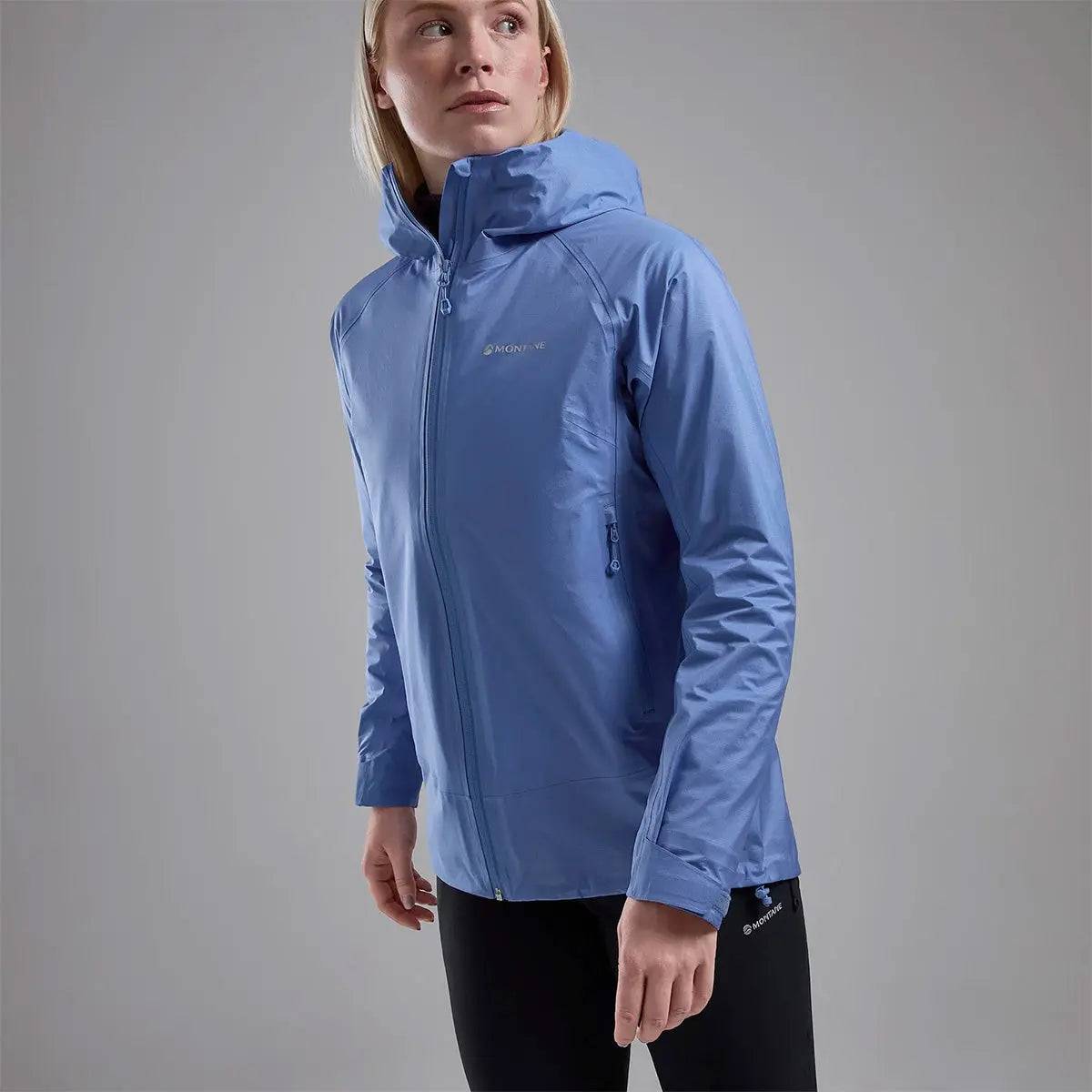 Model in Montane Women's Cetus Lite Waterproof Jacket in light blue, highlighting its ergonomic fit and lightweight waterproof fabric.