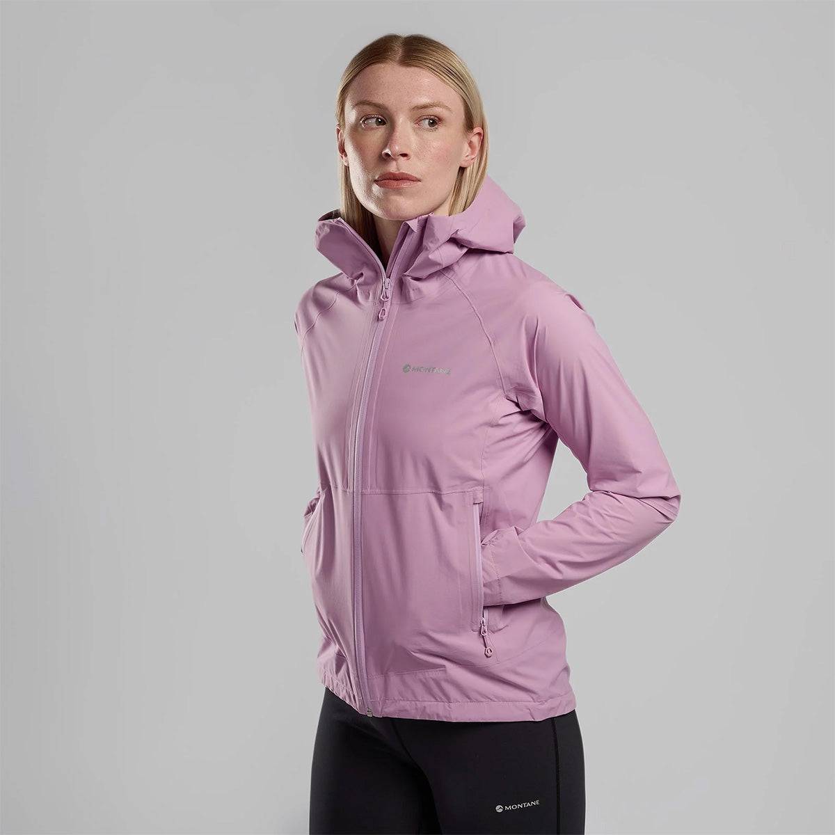 Front view of woman wearing pink Montane Womans Minimus Lite Waterproof Jacket, ideal for lightweight waterproof protection in outdoor conditions.