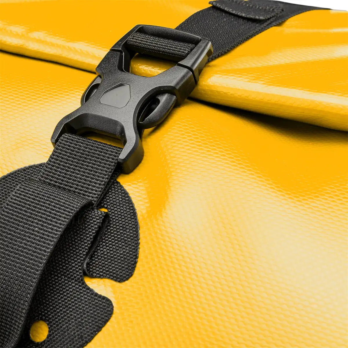 Close-up of buckle on yellow Ortlieb Rack Pack 31L Waterproof Duffle Bag highlighting secure roll-top fastening system.