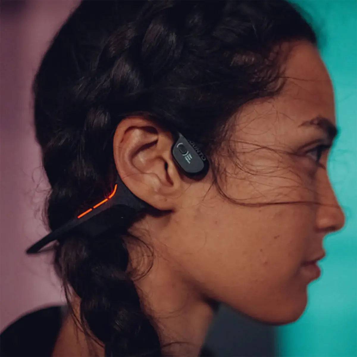 A person wearing Suunto Wing Open Ear Bluetooth Headphones, showing the secure fit and LED safety lights for outdoor activities.
