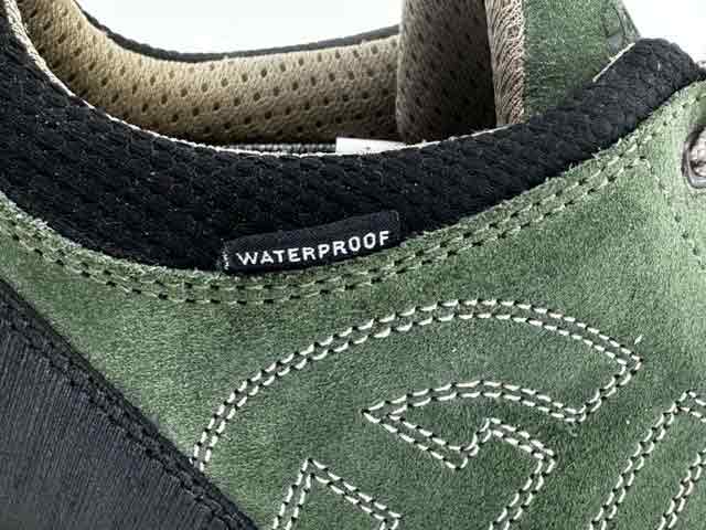Close-up of green Altberg Wensley Waterproof Outdoor Shoe showing waterproof label and detailed suede stitching for premium quality.