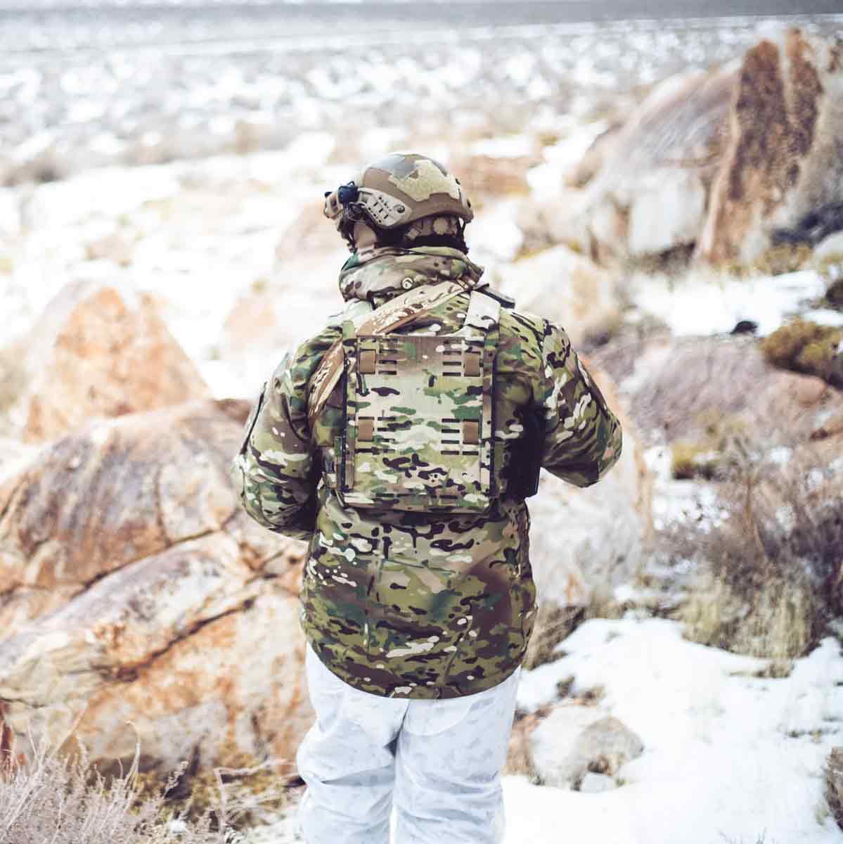 Person wearing the Keela Mk5 Waterproof Jacket MTC in a snowy outdoor environment, demonstrating its rugged and weather-resistant design.
