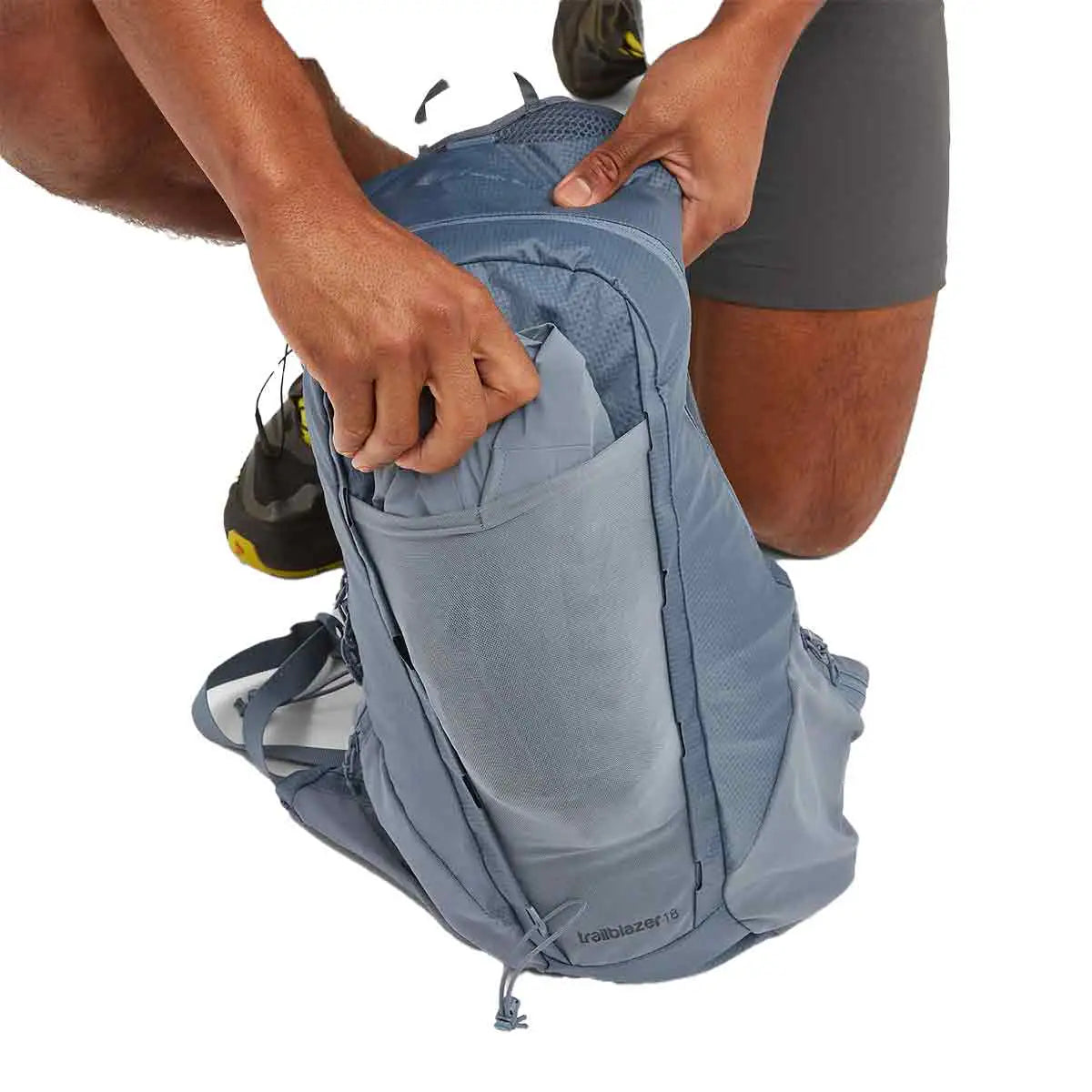 Man accessing the main compartment of the Montane Trailblazer 18L Backpack, demonstrating its spacious storage. from John Bull Clothing
