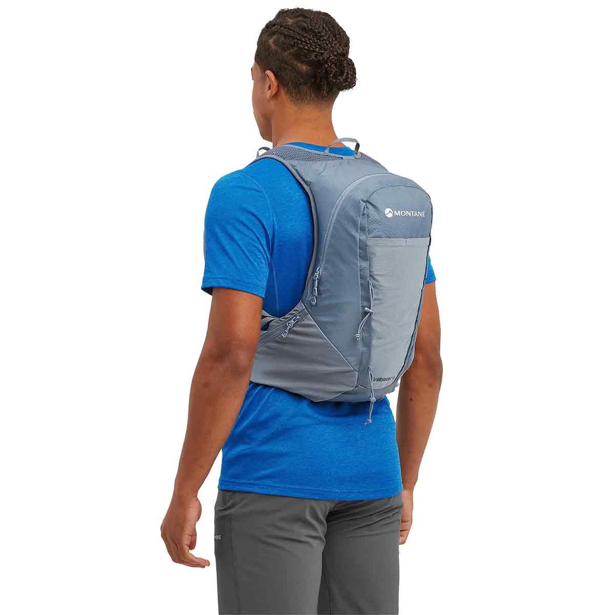 Man wearing the Montane Trailblazer 18L Backpack in blue, demonstrating its ergonomic fit and lightweight feel.