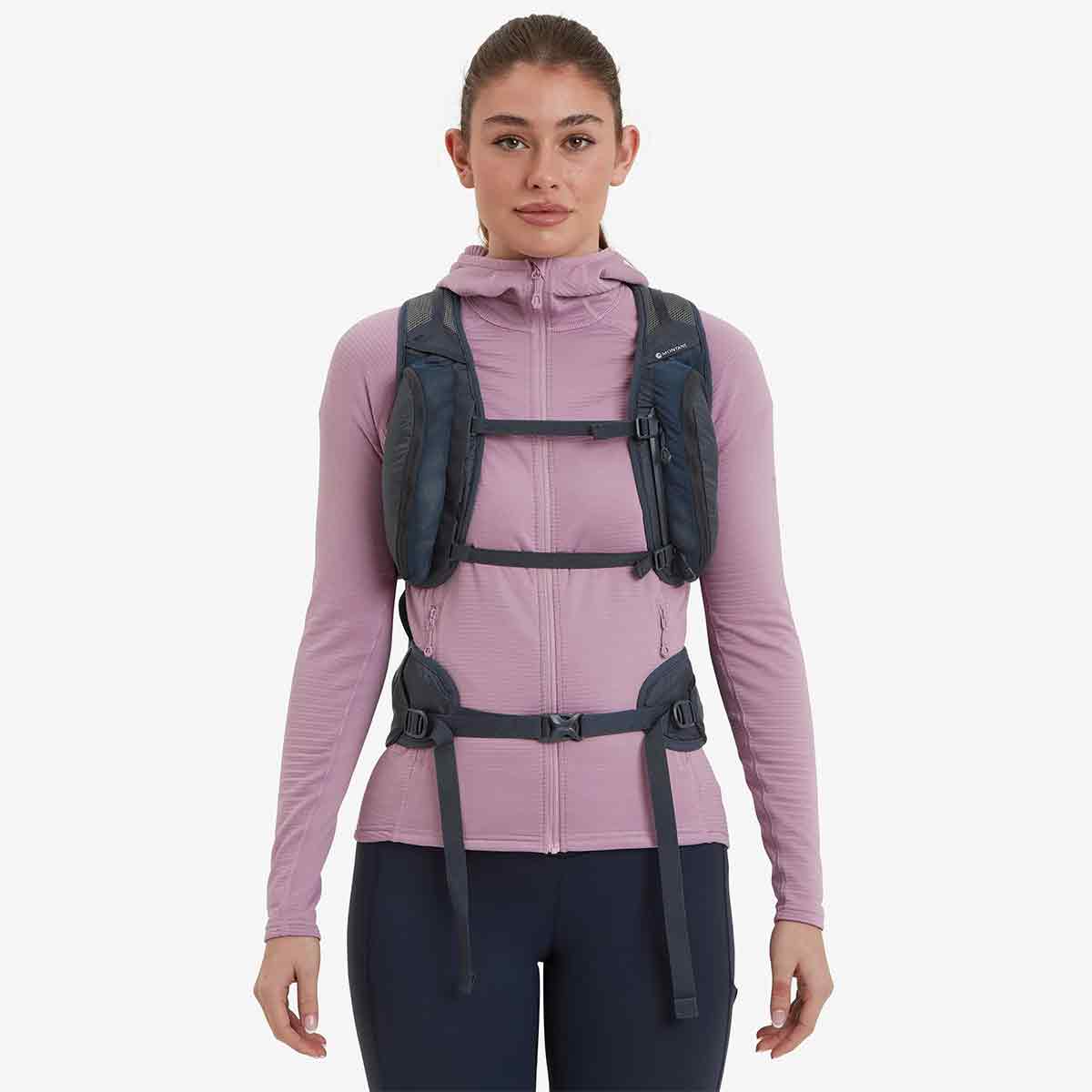 Woman wearing Montane Trailblazer 24L Womens Rucksack, showcasing its ergonomic fit, chest straps, and front storage pockets for easy access.