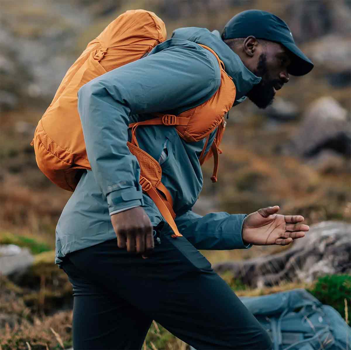 Trail runner wearing the Montane Trailblazer 25L Rucksack in orange, demonstrating its lightweight and ergonomic design.