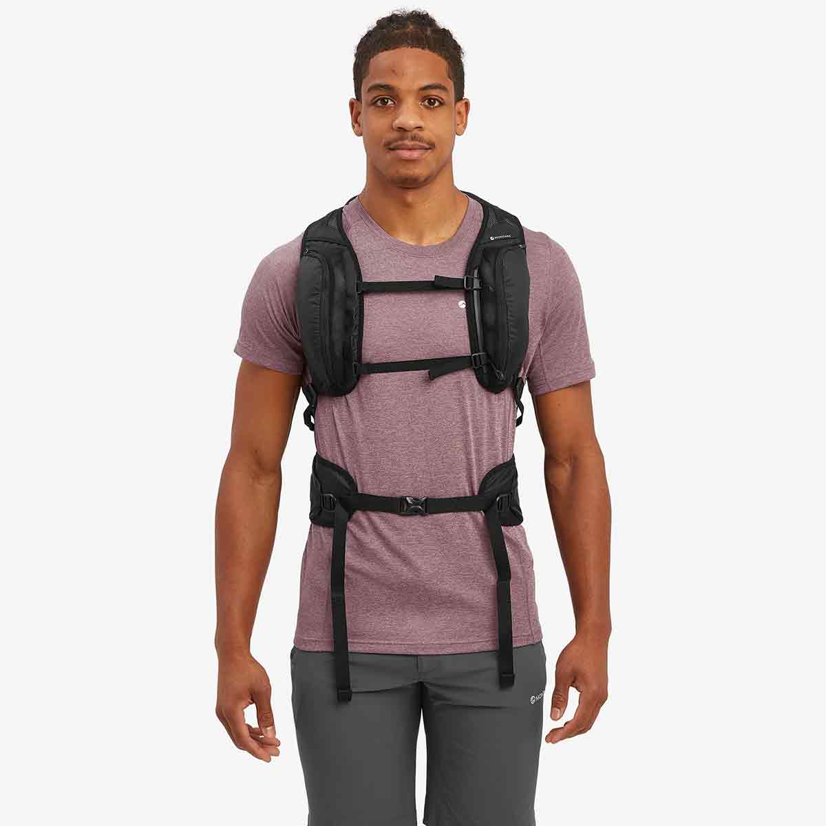 Front view of a model wearing the Montane Trailblazer 25L Rucksack in black, showcasing its adjustable chest and waist straps.