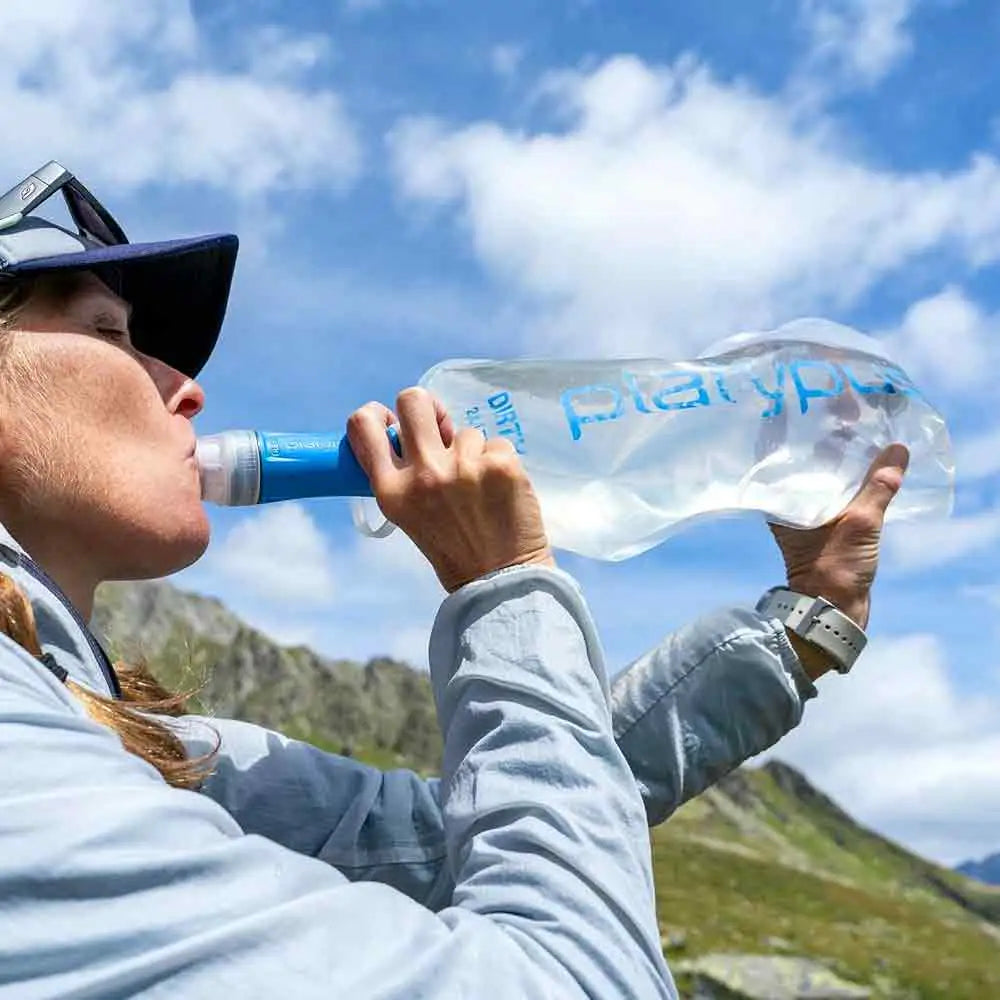 Camper drinking directly from the Platypus Quickdraw 2L Filter System, highlighting its convenience for outdoor hydration needs. from John Bull Clothing