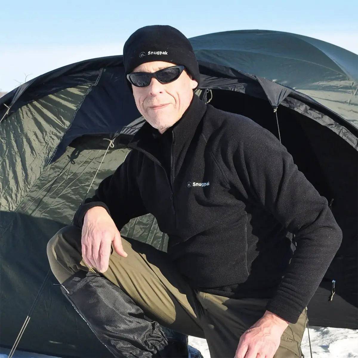 Man wearing Snugpak Impact Black Fleece Shirt in a cold outdoor setting, showcasing its warmth and versatility for camping and outdoor adventures.