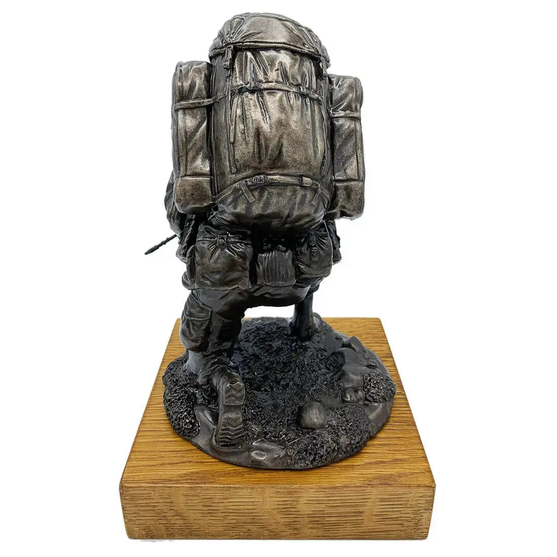 Rear view of Bronze Resin Kneeling Combat Statue with Helmet, highlighting detailed Bergen backpack and textured terrain on oak wooden base.