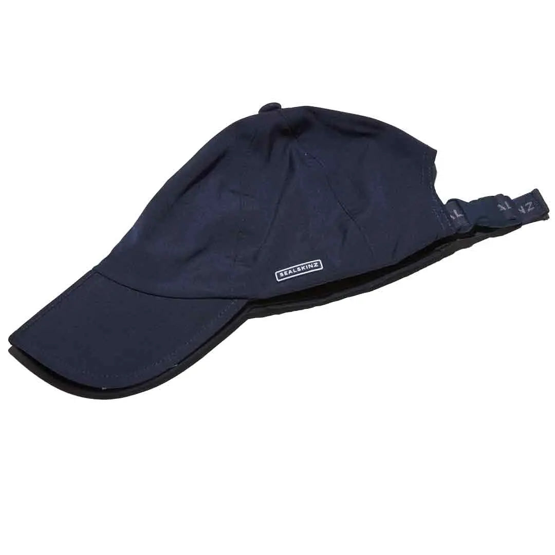 Folded navy Sealskinz Salle Waterproof Peak Cap showing adjustable strap and compact design for easy packing and portability.