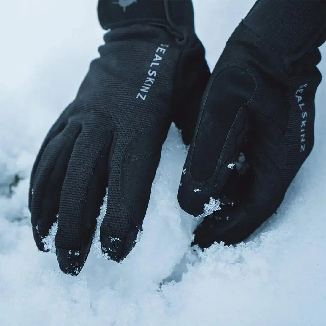 Sealskinz Waterproof All Weather Gloves in use in snowy conditions, demonstrating waterproof protection and grip in cold weather.