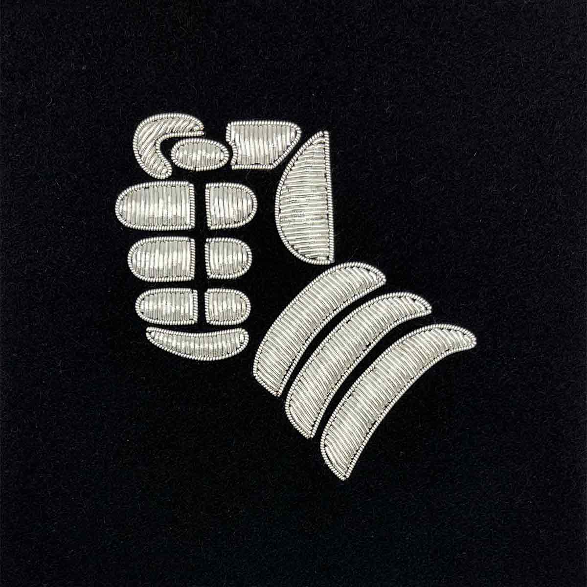 Embroidered silver gauntlet insignia on a black background. Perfect for framed military presentations and Army memorabilia collections.